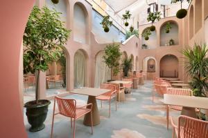 een restaurant met tafels en stoelen en potplanten bij Leon's Place Hotel In Rome in Rome