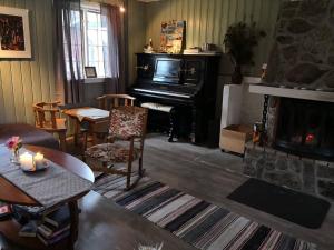 a living room with a fireplace and a piano at Yttervik gard in Steinkjer