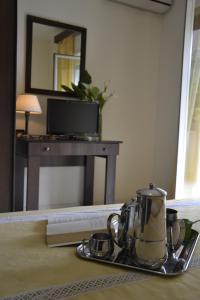 a tea kettle on a tray on a table with a mirror at Hotel Marabel in SantʼAlessio Siculo