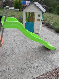a green slide in front of a play house at Chez isa in Massilly