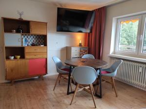 - une salle à manger avec une table, des chaises et une télévision dans l'établissement Ferienwohnung Vogelnest im Schwarzwald, à Baiersbronn