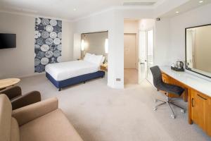 a hotel room with a bed and a desk at Holiday Inn Peterborough West, an IHG Hotel in Peterborough