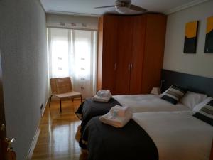 pokój hotelowy z dwoma łóżkami i krzesłem w obiekcie Greta Etxea w mieście Arróniz
