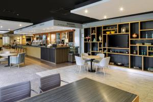 a lobby with a bar and tables and chairs at Holiday Inn Peterborough West, an IHG Hotel in Peterborough