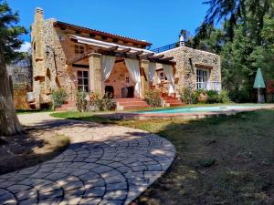 una casa in pietra con un sentiero che la porta di Rock House's Villa Melody a Plataniás
