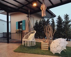 a porch with a swinging chair and a house at Capital O 75422 Million Pillows in Chiang Mai