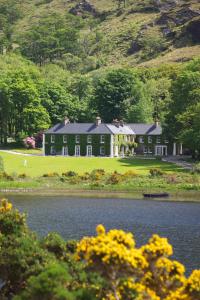 a large house sitting next to a body of water at Delphi Lodge in Leenaun