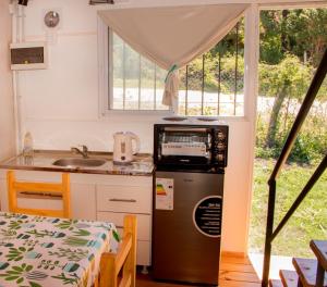 a kitchen with a refrigerator and a sink and a window at Cabañas Guayacán in Bialet Massé