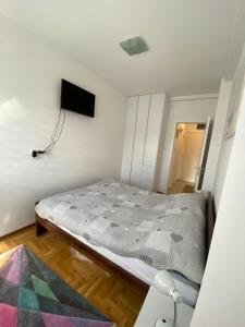 um quarto com uma cama e uma televisão na parede em Apartment Nena em Trebinje
