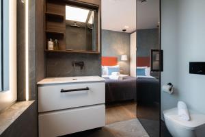 伦敦Urban Rest Camden的带水槽、马桶和床的浴室