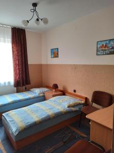 ルブリンにあるHostel Słodki Senのベッド2台とデスクが備わるホテルルームです。