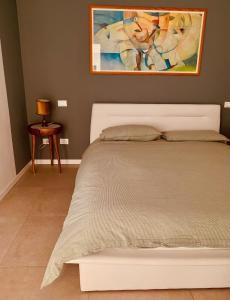 Narni ScaloにあるDolce Nera B&Bの白いベッド1台付きのベッドルーム1室(壁に絵画付)