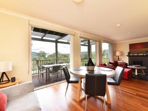 uma sala de estar com mesa e cadeiras em Villa 2br Moscato Villa located within Cypress Lakes Resort em Pokolbin