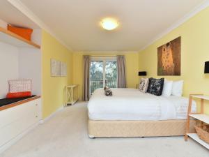 a bedroom with a large white bed and a window at Villa 3br Penivity Villa located within Cypress Lakes Resort in Pokolbin