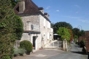 una vieja casa de ladrillo con una puerta delante de ella en Maison de charme en Périgord 10 personnes La maison d'Albertine, en Peyrillac-et-Millac