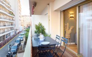 a balcony with a blue table and chairs on a building at Host Inn Sweet Croisette in Cannes