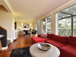 a living room with a red couch and a table at Villa 2br Pokolbin Villa located within Cypress Lakes Resort in Pokolbin