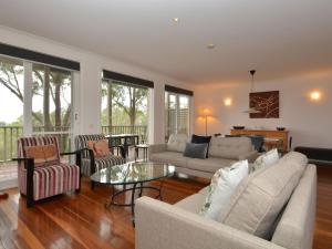ein Wohnzimmer mit einem Sofa und einem Tisch in der Unterkunft Diciotto sleeps 18 Villas located within Cypress Lakes Resort in Pokolbin