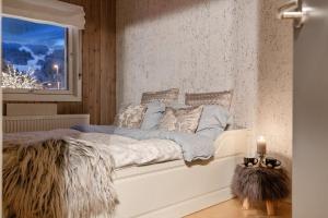a white bed in a room with a window at In the middle of Trysilfjellet - Welcome Center - Apartment with 3 bedrooms - By bike arena and ski lift in Trysil