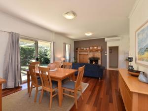 a dining room and living room with a table and chairs at Somerville Wine Cottage Hideaway 3-Bedroom Cottage Near Broke Wineries in Broke
