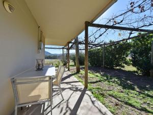 a patio with two chairs and a table with a view at Somerville Wine Cottage Hideaway 3-Bedroom Cottage Near Broke Wineries in Broke