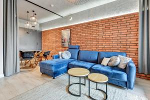 a living room with a blue couch and a brick wall at Granaria Comfort Apartments in Gdańsk