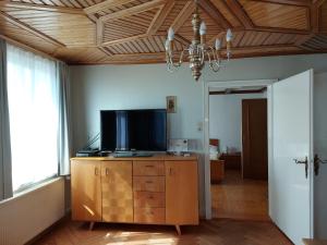 una sala de estar con TV en una cómoda de madera en Ferienhaus und Ferienappartements Brunner en Höchst