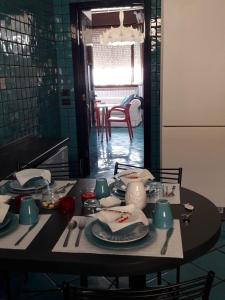 a table with plates and utensils in a kitchen at Soffio Di Mare in Porto Recanati