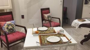 a room with two chairs and a table with plates on it at Archè in Syracuse