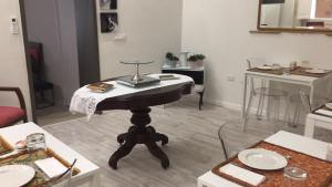 a living room with a table in the middle of a room at Archè in Syracuse