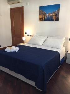een slaapkamer met een groot bed en een blauwe deken bij Dali House Airport And Fiera in Fiumicino