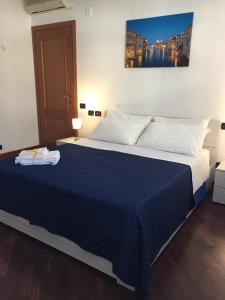 a bedroom with a large bed with a blue blanket at Dali House Airport And Fiera in Fiumicino