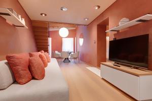 sala de estar con TV de pantalla plana grande en 1881 LUXURY SUITES, en Verona