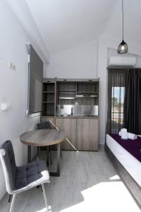 a room with a table and a bed and a kitchen at GERANI apartments in Órmos