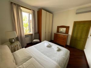 ein Schlafzimmer mit einem Bett, einer Kommode und einem Fenster in der Unterkunft Colosseum Street in Rom