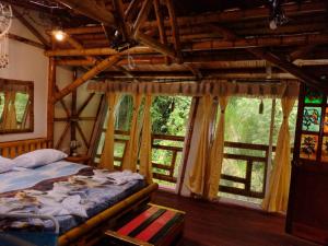 a bedroom with a bed in a room with windows at Hospedaje Rural Tupinamba in Ibagué