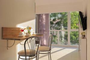 uma cozinha com uma mesa e duas cadeiras e uma janela em Квартира для 4-х с двумя санузлами и балконом для курения em Kiev