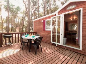 a patio with a table and chairs on a deck at Bungalow Maite in L'Escala