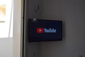 a tv on a wall with a youtube sign on it at Sweet Memories in Malia