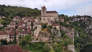 une ville au bord d'une montagne avec un château dans l'établissement Le Refuge du Cele, à Cabrerets