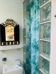 W łazience znajduje się prysznic, lustro i umywalka. w obiekcie King almost by the sea w Zandvoort