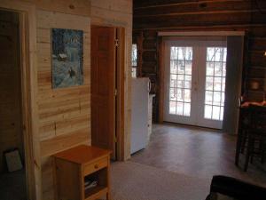 un soggiorno con pareti in legno e frigorifero di Renegade Log Cabin a Custer