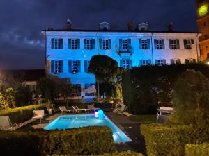 een groot wit gebouw met een zwembad ervoor bij Villa Rambaudi in Sanfrè