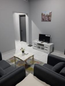 Sala de estar con 2 sofás y mesa de centro en Paris Furnished Apartments - Tabasum Group, en Ajman