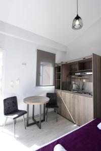 a kitchen with a table and two chairs in a room at GERANI apartments in Órmos