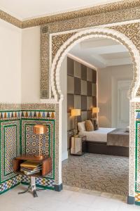 an archway in a bedroom with a bed and a table at Magdalena Premium Suites in Seville