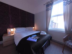 a hotel room with a bed and a window at Chiltern Guest House in Whitby