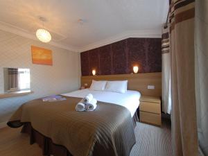 a hotel room with a bed with towels on it at Chiltern Guest House in Whitby