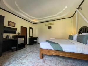a bedroom with a bed and a desk and a television at Phi Phi Villa Resort-SHA Extra Plus in Phi Phi Islands