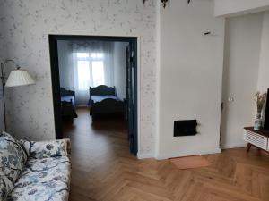 ein Wohnzimmer mit Sofa und ein Schlafzimmer in der Unterkunft Esplanaadi Luxury Apartment in Pärnu
